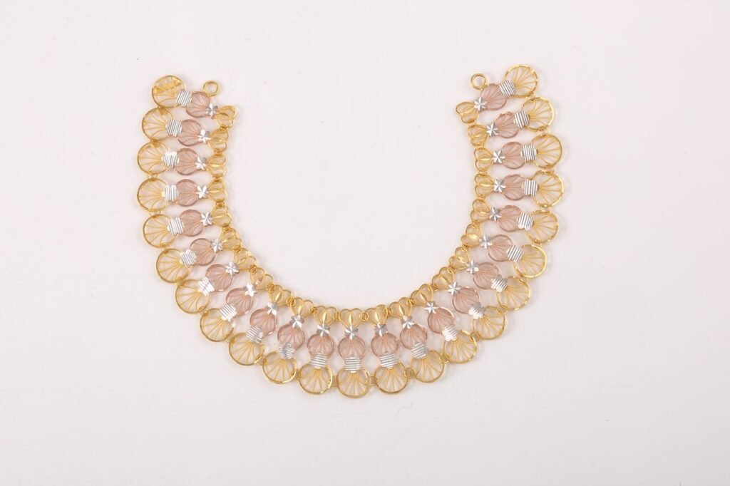 Sophisticated gold and silver necklace showcasing intricate design on a clean white surface.